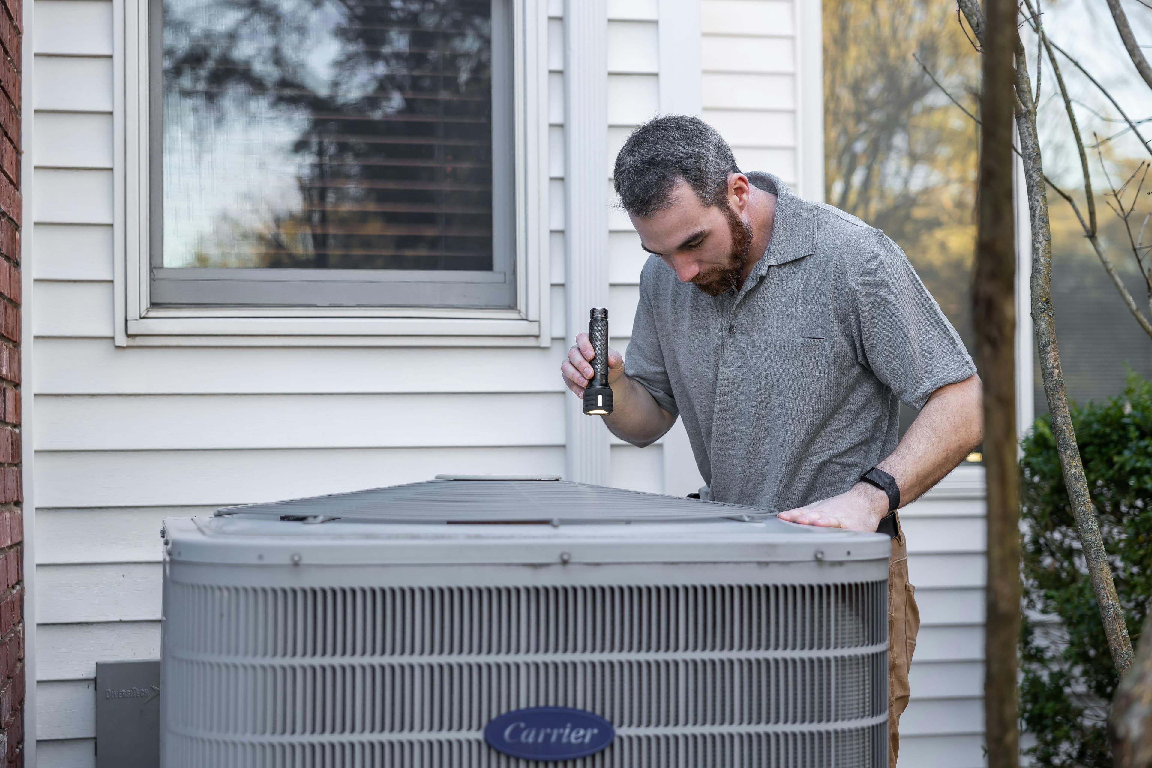 Tech servicing a condenser